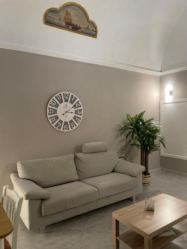 a living room with a couch and a clock on the wall at Casa Moly in Monopoli