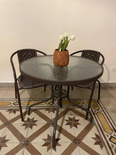 a table with two chairs and a vase with white flowers at Casa Moly in Monopoli