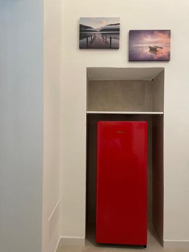 a red refrigerator in a room with two pictures on the wall at Casa Moly in Monopoli