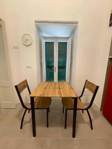 a wooden table and two chairs in a room at Casa Moly in Monopoli