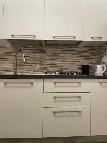 a kitchen with white cabinets and a sink at Casa Moly in Monopoli
