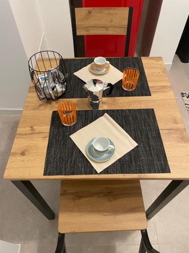 a wooden table with two plates and bowls on it at Casa Moly in Monopoli