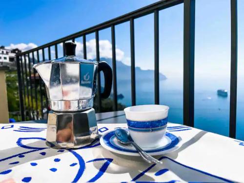 a coffee maker and a cup on a table on a balcony at Villa Alba - Zaffiro in Amalfi