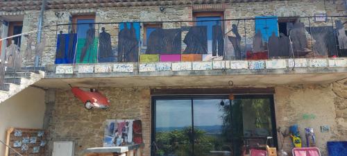 a balcony with colorful umbrellas on a building at tempepailla in Roynac
