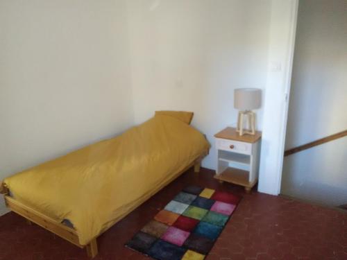 une petite chambre avec un lit et une table de chevet dans l'établissement La Bastide des Jourdans logement entier Duplex, à La Bastide-des-Jourdans