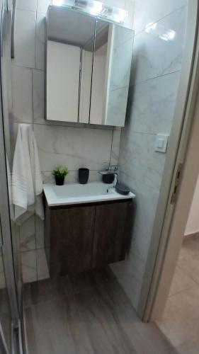 a small bathroom with a sink and a mirror at EVDOKIAS Apt,brand new 2025 modern Apt in the center of Alikanas in Alikanas