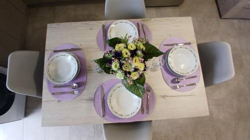 a table with purple plates and a bouquet of flowers at EVDOKIAS Apt,brand new 2025 modern Apt in the center of Alikanas in Alikanas
