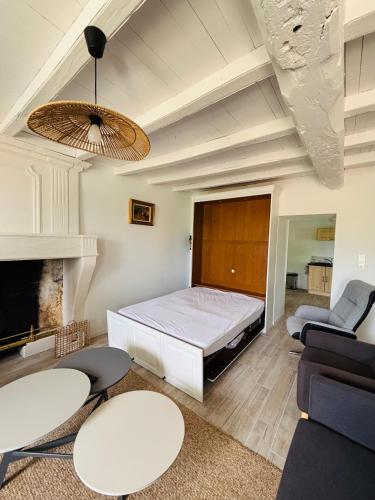 Cette chambre comprend un lit, un canapé et des chaises. dans l'établissement roumeneche THERMALISME jonzac au sejour ou a la semaine, à Marignac