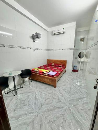 a room with a bed and a table in it at Hotel Lâm Phương Luxury in Ấp Long Tương