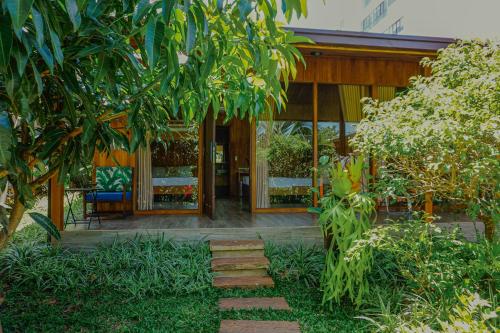 a house with a pathway leading to the front door at An Land Garden Homestay in Buôn Alê (1)