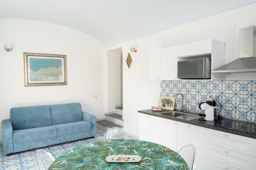 a living room with a blue couch and a table at Villa Alba - Rubino in Amalfi