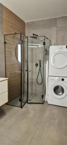 a bathroom with a shower and a washing machine at Maze Apartments - Perfectly located brand new flats in Tel Aviv