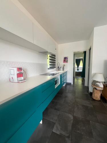 Il comprend une cuisine avec des placards bleus et blancs et du carrelage. dans l'établissement Appartement en lisière de forêt, à Wingen-sur-Moder