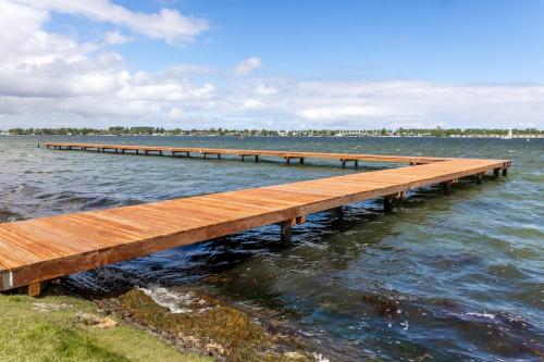 a wooden pier in the middle of the water at Glamping De Zuidvliet Nr 12 in Wolphaartsdijk
