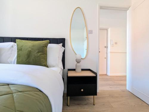 a bedroom with a bed and a mirror on a table at Saffron Court Apartments - Apt 14 in High Wycombe