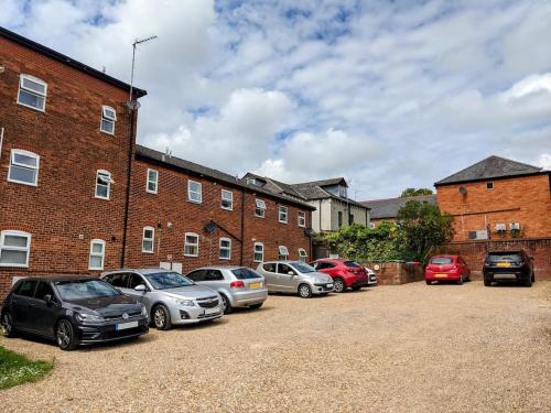 a row of cars parked in front of a brick building at Saffron Court Apartments - Apt 14 in High Wycombe