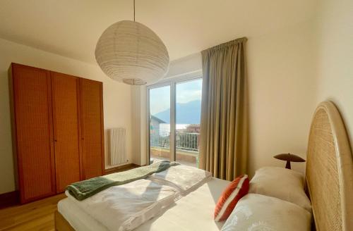 a bedroom with a bed and a large window at HomeTerra in Brenzone sul Garda