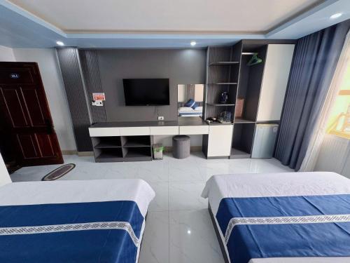 una camera d'albergo con due letti e una televisione di New Way Hotel a Cat Ba