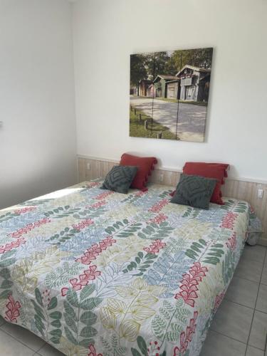 a bedroom with a bed with a quilt on it at Villa HESTIA in Le Teich