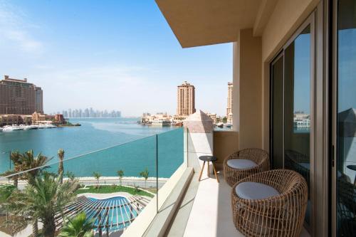 a balcony with chairs and a view of the water at The St. Regis Marsa Arabia Island, The Pearl Qatar in Doha