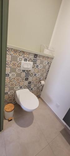 une salle de bain avec toilettes et un mur carrelé dans l'établissement Il Vialetto - Roma, à Jeumont
