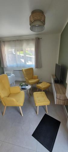 d'un salon avec des chaises jaunes et une télévision. dans l'établissement Il Vialetto - Roma, à Jeumont