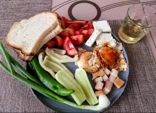 a plate of food with a sandwich and fruits and vegetables at RUSTIC SEJOUR,Roşia Montana in Roşia Montană