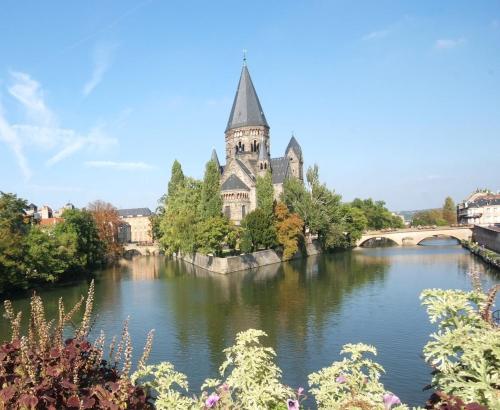a building with a tower and a bridge over a river at Le Refuge, Pet friendly, Free Parking in Pagny-sur-Moselle
