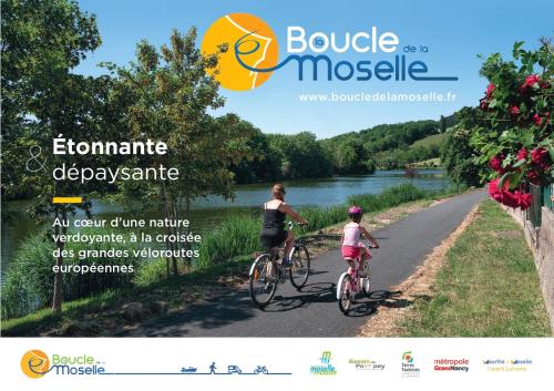 a woman and a child riding bikes down a road at Le Refuge, Pet friendly, Free Parking in Pagny-sur-Moselle
