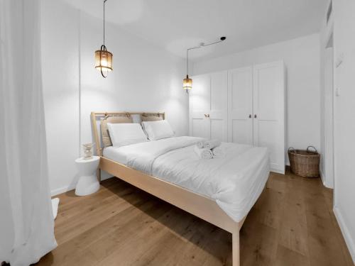 una camera da letto bianca con un grande letto con lenzuola bianche di Ritzside Marina Stay a Herzliya B