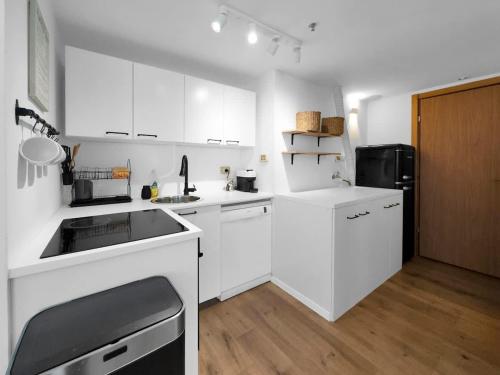 a kitchen with white cabinets and a black refrigerator at Ritzside Marina Stay in Herzliya B