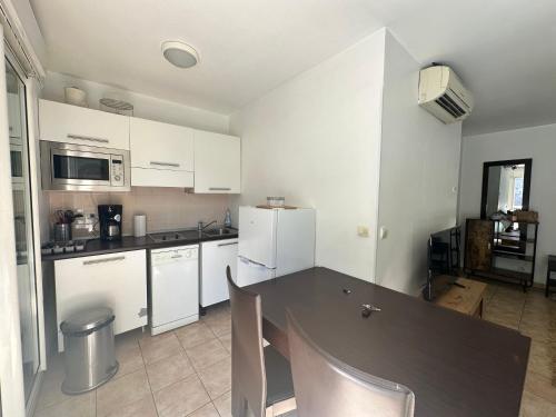 une cuisine avec une table noire et des appareils électroménagers blancs dans l'établissement Cute studio Beausoleil 10 steps to Monaco, à Beausoleil