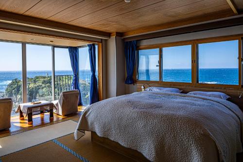 a bedroom with a bed with a view of the ocean at Ocean View Hiromi SPA Hotel温泉と絶景の宿 in Shimoda
