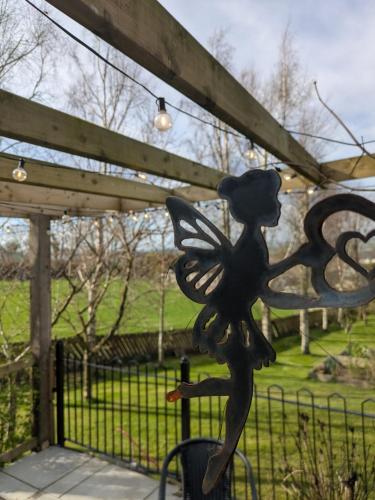 a statue of a girl with a butterfly on a gate at The Loft at Rowantree Cottage in Dromara