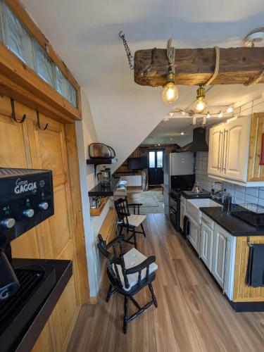 a kitchen with wooden cabinets and chairs in a house at The Loft at Rowantree Cottage in Dromara