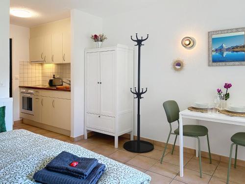 eine Küche mit einem Tisch und einem weißen Schrank in der Unterkunft Studio Gornera - Charming & Cozy in Zermatt
