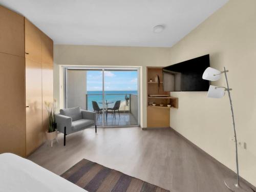 a bedroom with a living room with a view of the ocean at The Sharon Secret Pearl in Herzliyya B