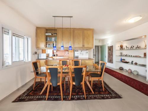 a kitchen with a dining room table and chairs at Dreamy Hilltop Grand Apartment in Herzliyya B