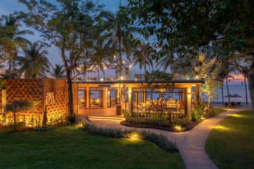 a house with lights in the yard at night at Anantara Hua Hin Resort in Hua Hin