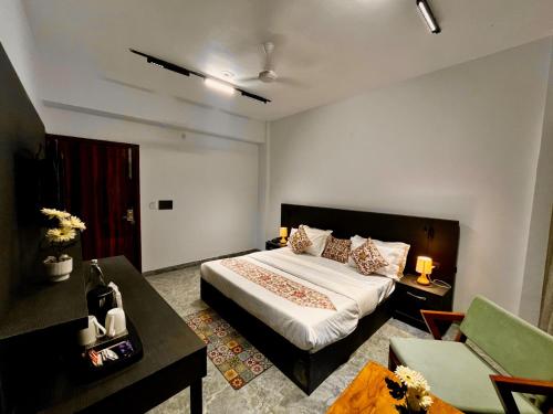 a bedroom with a bed and a desk and a couch at Sitara Hotel & Resorts, Haridwar in Haridwār