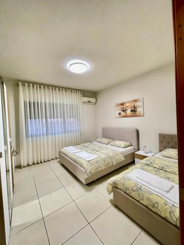 a bedroom with two beds and a window at ShkodraStay in Shkodër