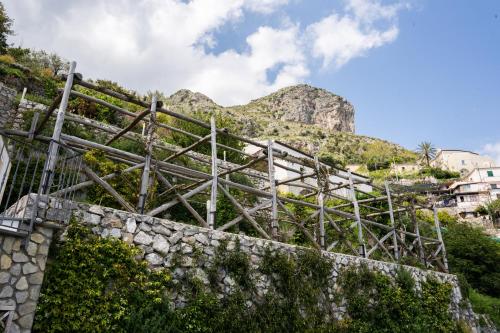 a stone wall with a mountain in the background at Villa Alba - Zaffiro in Amalfi