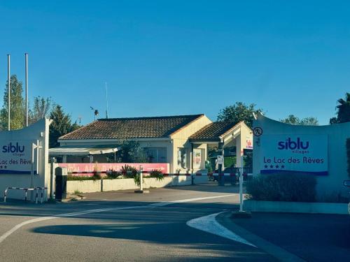 two signs in front of a gas station at Bungalow 341 pour 6 à 8 pers Camping Siblu 4 étoiles le Lac des Rêves in Lattes