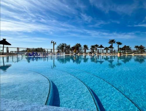 a large swimming pool with blue water at Bungalow 341 pour 6 à 8 pers Camping Siblu 4 étoiles le Lac des Rêves in Lattes