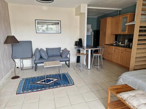 un salon avec un canapé et une cuisine dans l'établissement Studio avec terrasse vue mer, à Saint-Valery-en-Caux