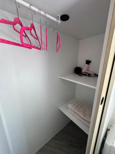 a room with white shelves with pink ribbon at Bungalow 341 pour 6 à 8 pers Camping Siblu 4 étoiles le Lac des Rêves in Lattes