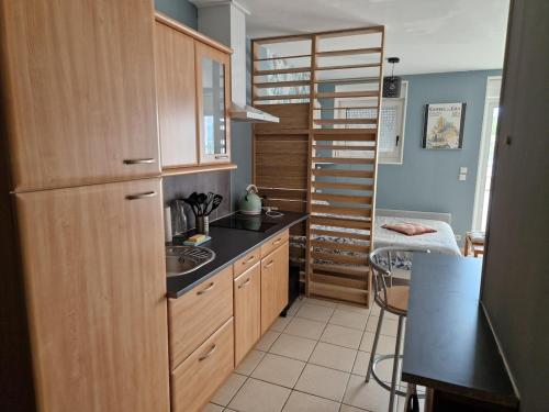 une cuisine avec un évier et un escalier en colimaçon dans l'établissement Studio avec terrasse vue mer, à Saint-Valery-en-Caux