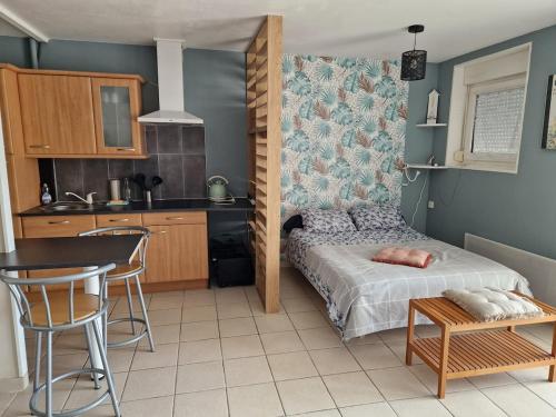une petite chambre avec un lit et une cuisine dans l'établissement Studio avec terrasse vue mer, à Saint-Valery-en-Caux