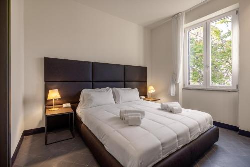 a bedroom with a large bed with two lamps and a window at LOCANDA SANTAMARINA Dimora di Charme in Palermo