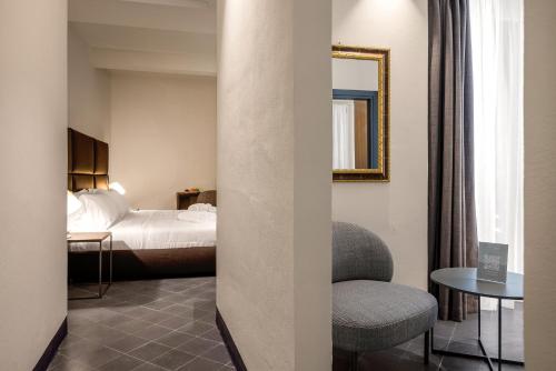 a hotel room with a bed and a chair at LOCANDA SANTAMARINA Dimora di Charme in Palermo